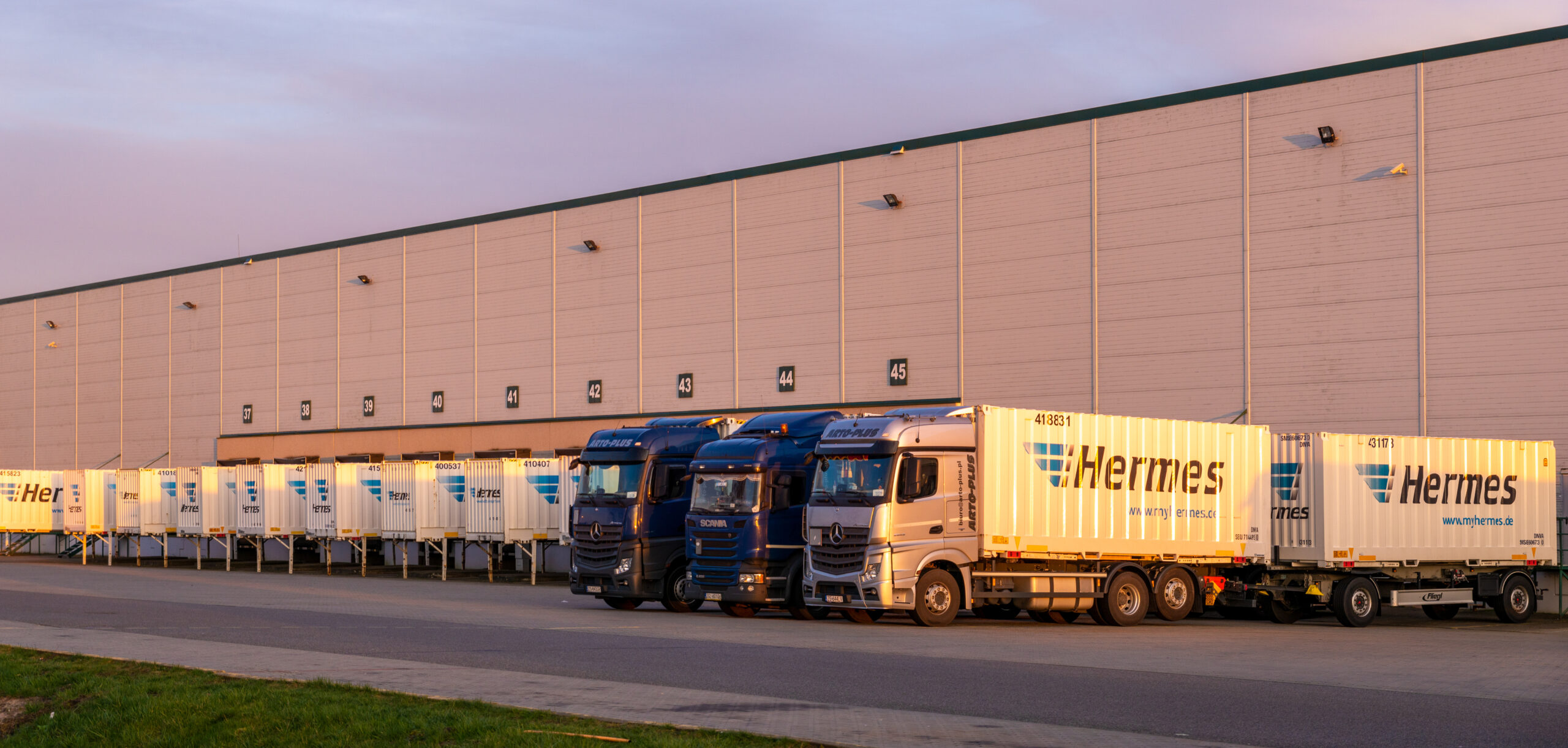 Scania and Mercedes trucks carrying containers with the Hermes logo - BorderGuru
